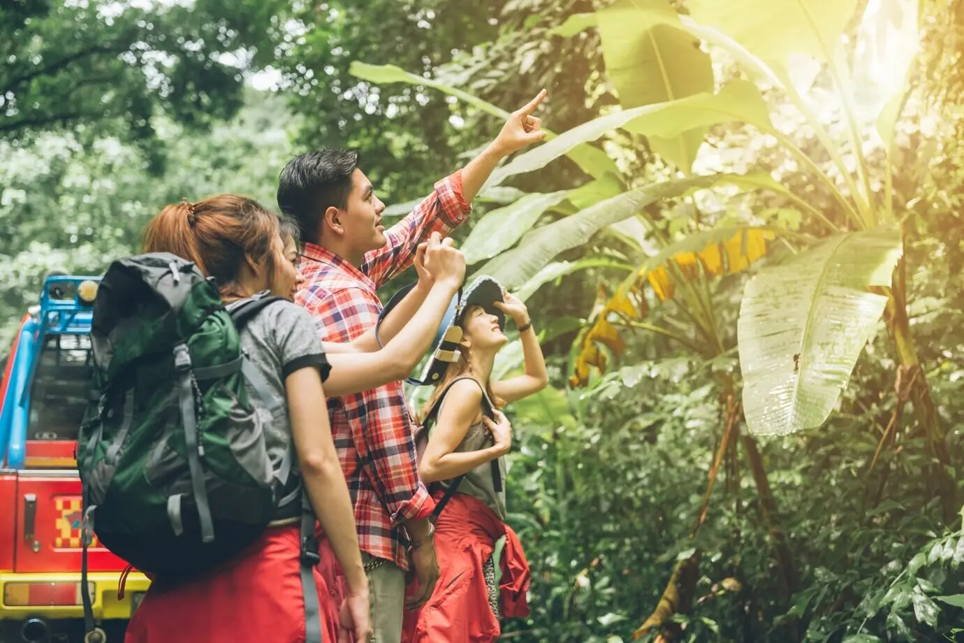 A couple or friends, smiling and happy, navigating together during a camping travel hike outdoors in a forest.