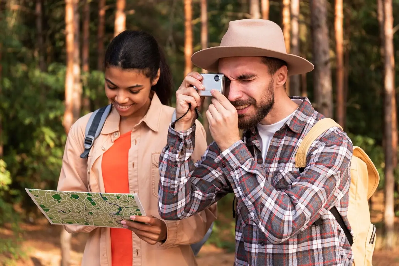A man takes photos while his girlfriend checks a map.